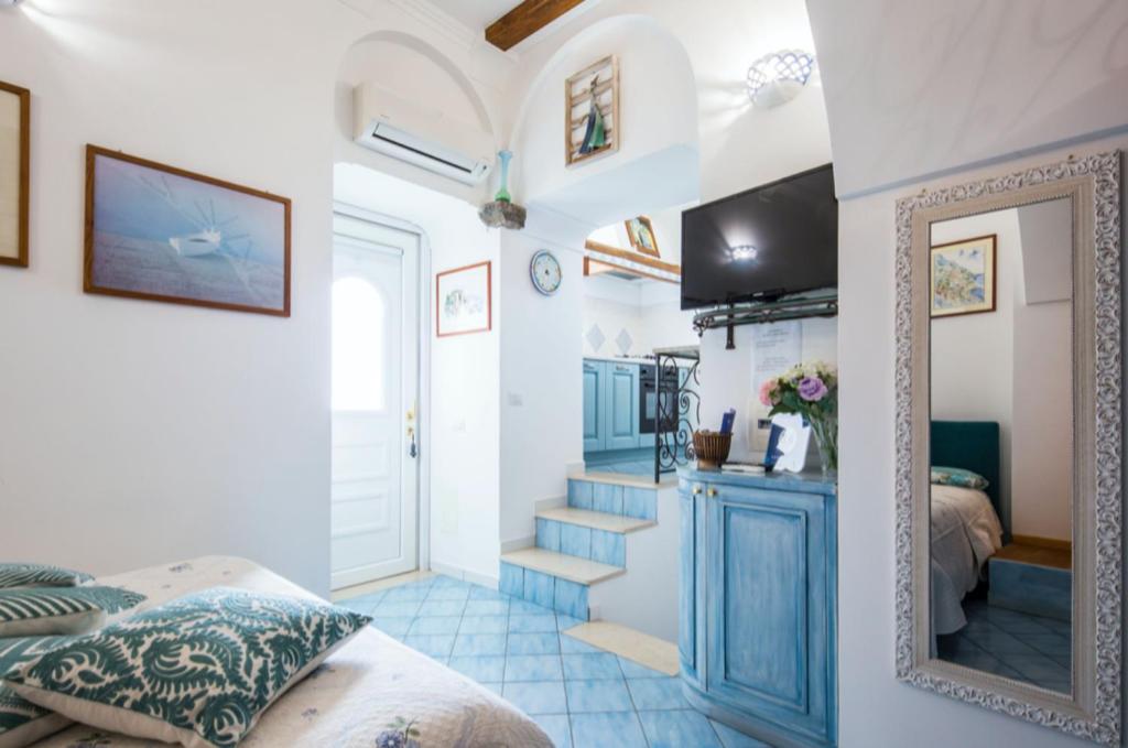 ミノーリにあるL'ARCO DEI QUATTRO VENTIのベッド1台、鏡、階段が備わる客室です。
