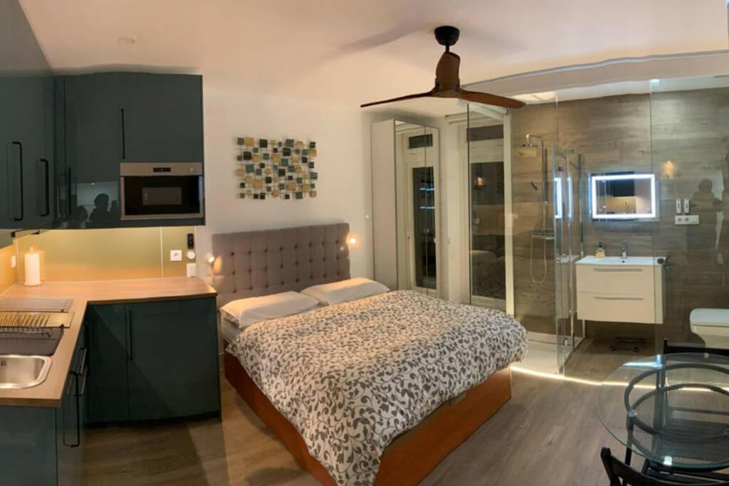 a bedroom with a bed and a kitchen at Moderno y funcional apartamento en el centro-El rastro in Madrid