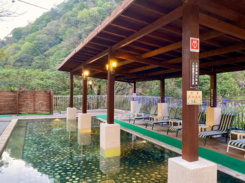 a swimming pool with a pavilion with chairs and a pool at Uni-Resort Ku-Kuan in Heping
