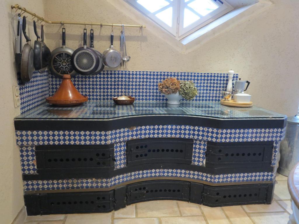 a kitchen with a blue tiled counter with pots and pans at Château l&#39;Hubertière, classé du tourisme 4 étoiles in Bouresse