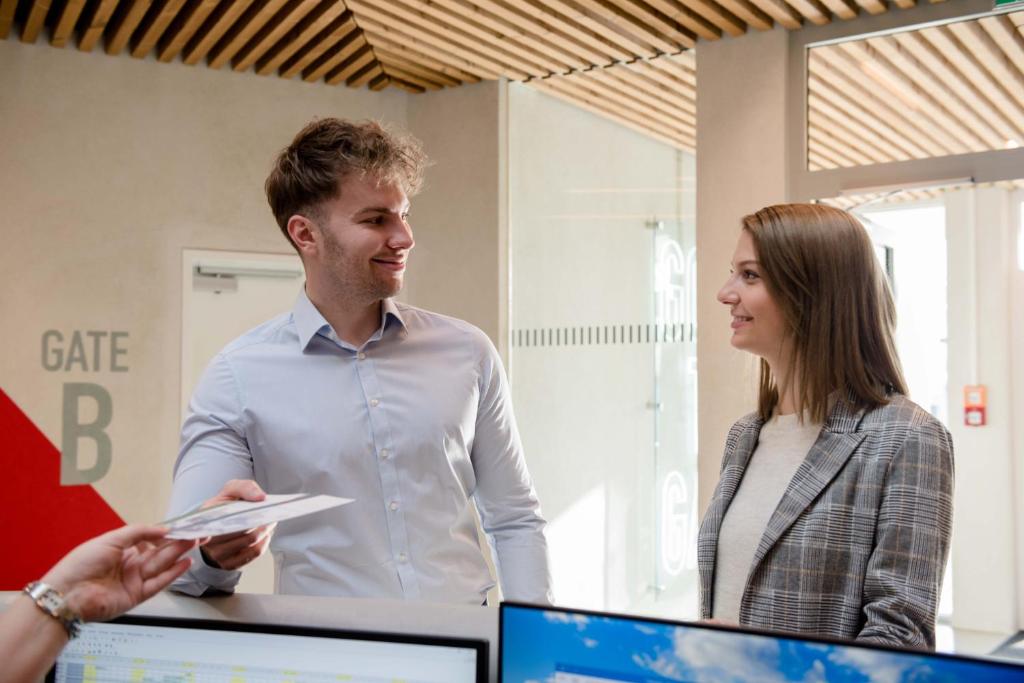 a man and a woman standing in front of a computer at Airbase Hotel in Kalsdorf bei Graz
