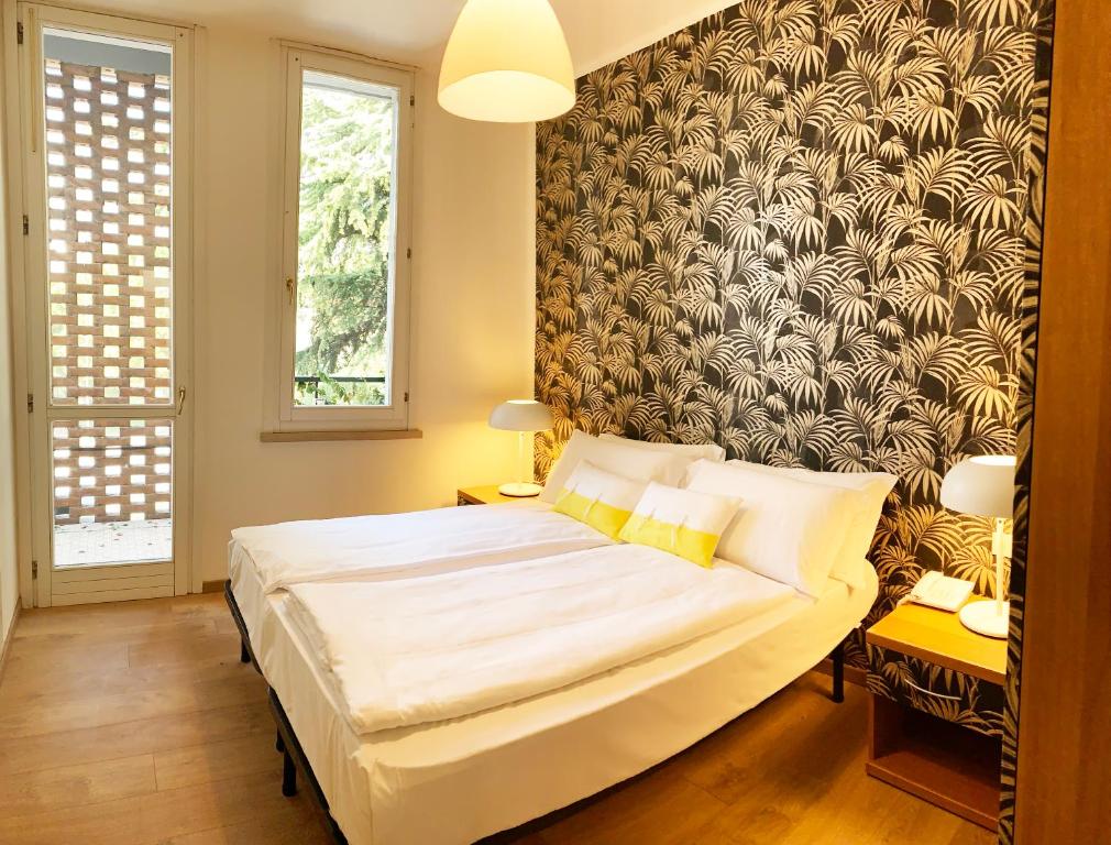 een slaapkamer met een groot bed en een muurschildering bij Ennesima Osteria con Alloggio - Bike Hotel in Toscolano Maderno