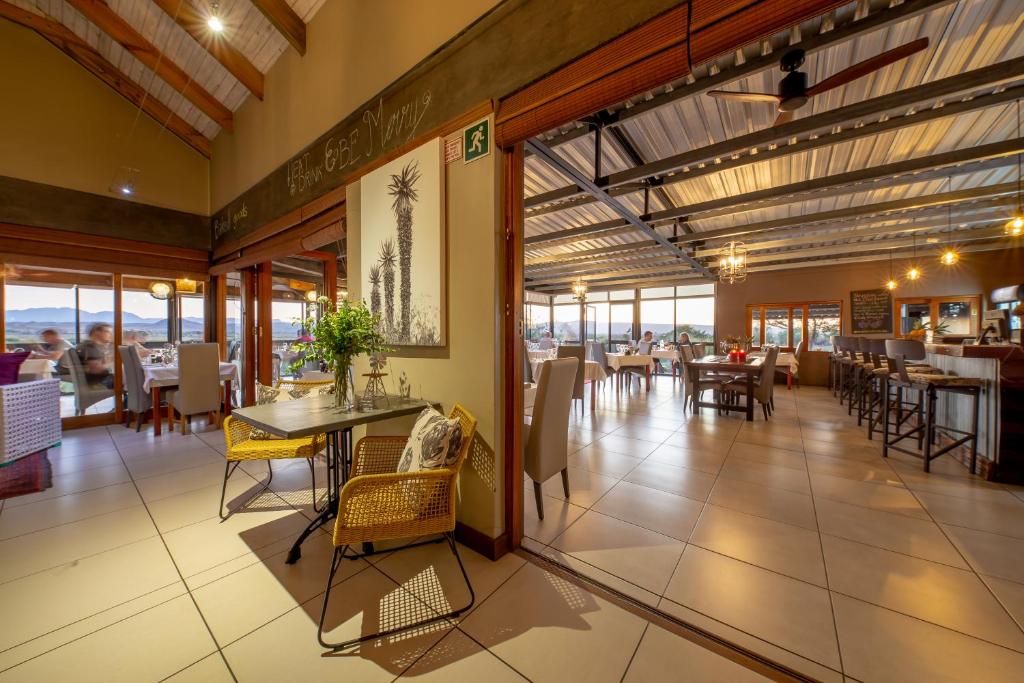 a restaurant with tables and chairs and a dining room at De Zeekoe Guest Farm in Oudtshoorn