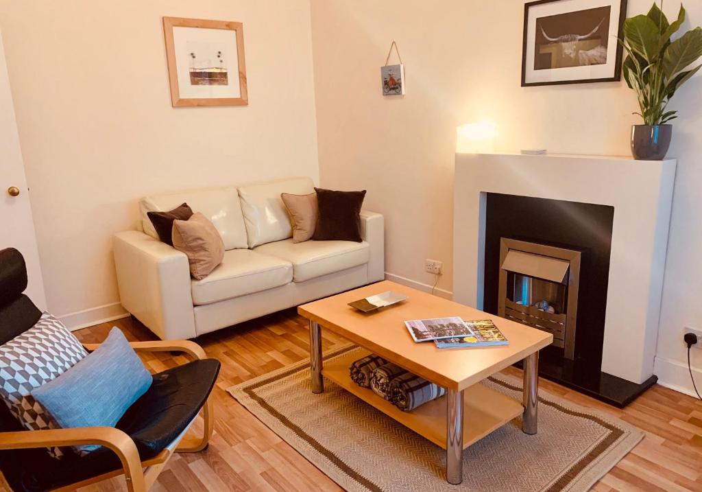 a living room with a couch and a fireplace at The St Mary's Street Residence in Edinburgh