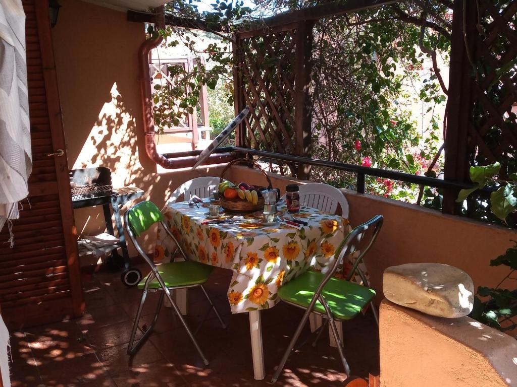 a table and chairs on a balcony with a table and fruit at La Bouganville in Villasimius