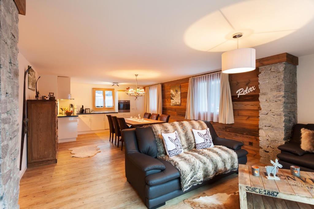 a living room with a couch and a kitchen at Apartment Bristolino in Saas-Fee
