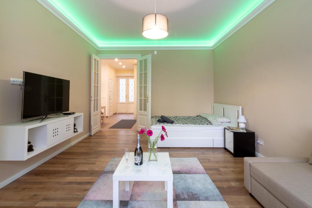 a living room with a bed and a white table at Nice and cozy apartment next to the Parliament in Budapest