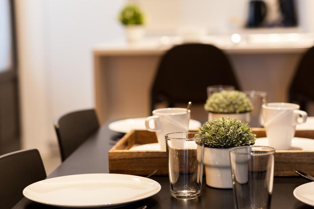 a table with white plates and glasses on it at Smartflats - Bourse Brussels in Brussels
