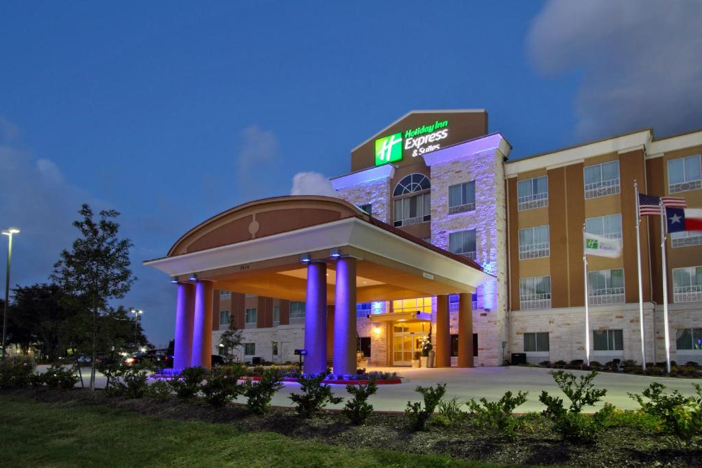 Holiday Inn Express & Suites Houston East - Baytown, an IHG Hotel في باي تاون: مبنى مستشفى أمامه أضواء أرجوانية