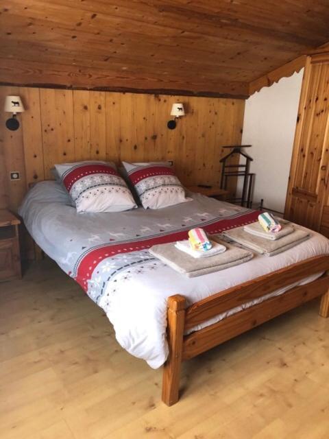 une chambre avec un lit dans une pièce en bois dans l'établissement Le chalet de Bernoline vaste appartement tout confort, à Beaufort