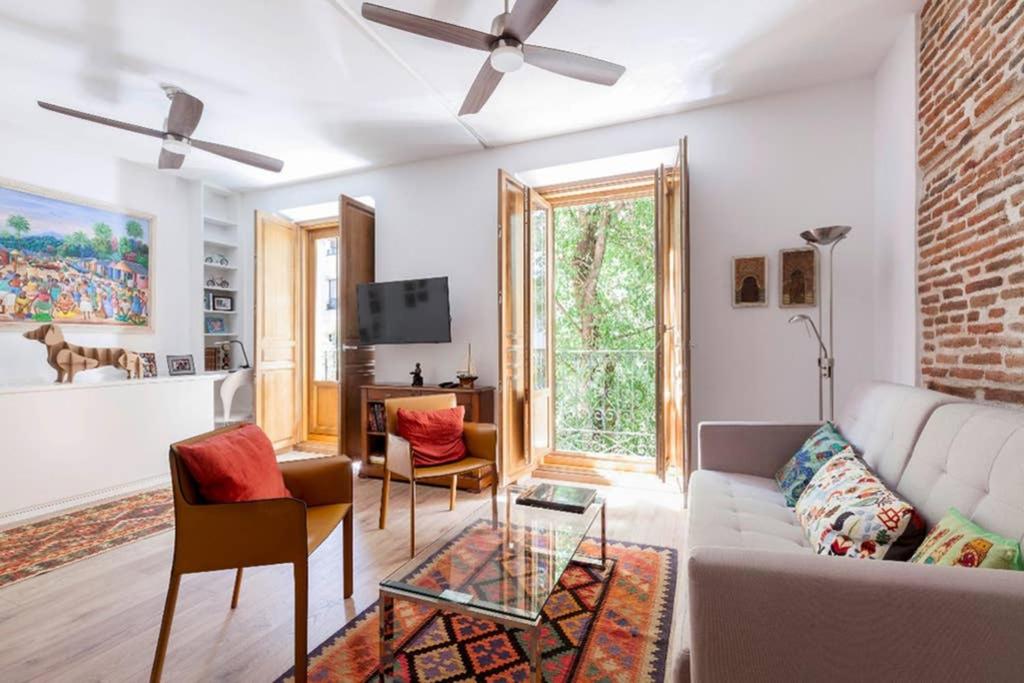 Chamberí Design Loft في مدريد: غرفة معيشة مع أريكة بيضاء وطاولة