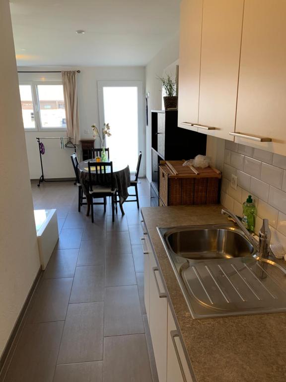 cocina y sala de estar con fregadero y mesa en C&C Eco Studio, en La Sonnaz