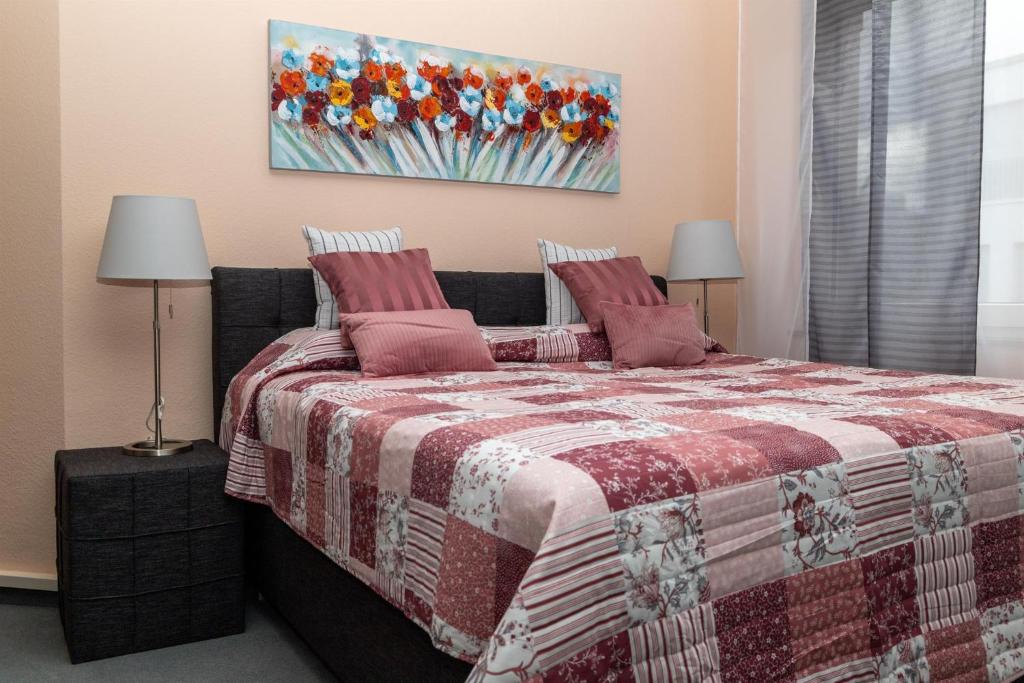 um quarto com uma cama com um cobertor e 2 candeeiros em BIT-City Studio und Appartement em Bitburg