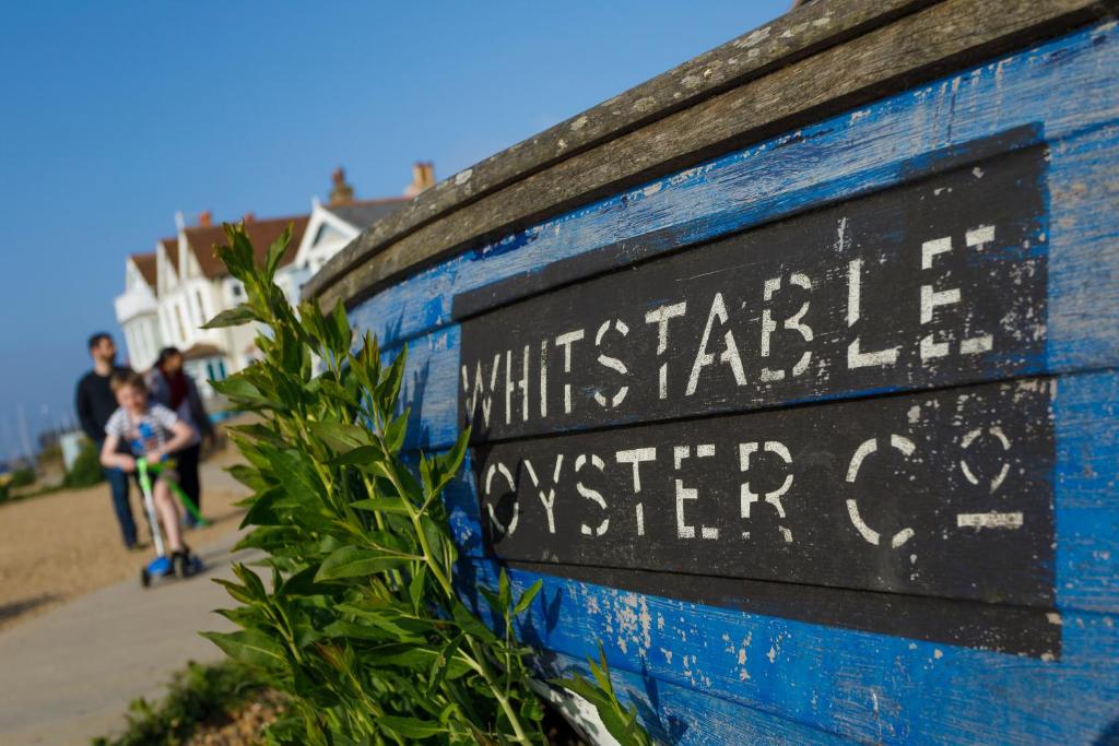 a blue wall with a sign that reads whitstable oyster co at No 10 in Whitstable