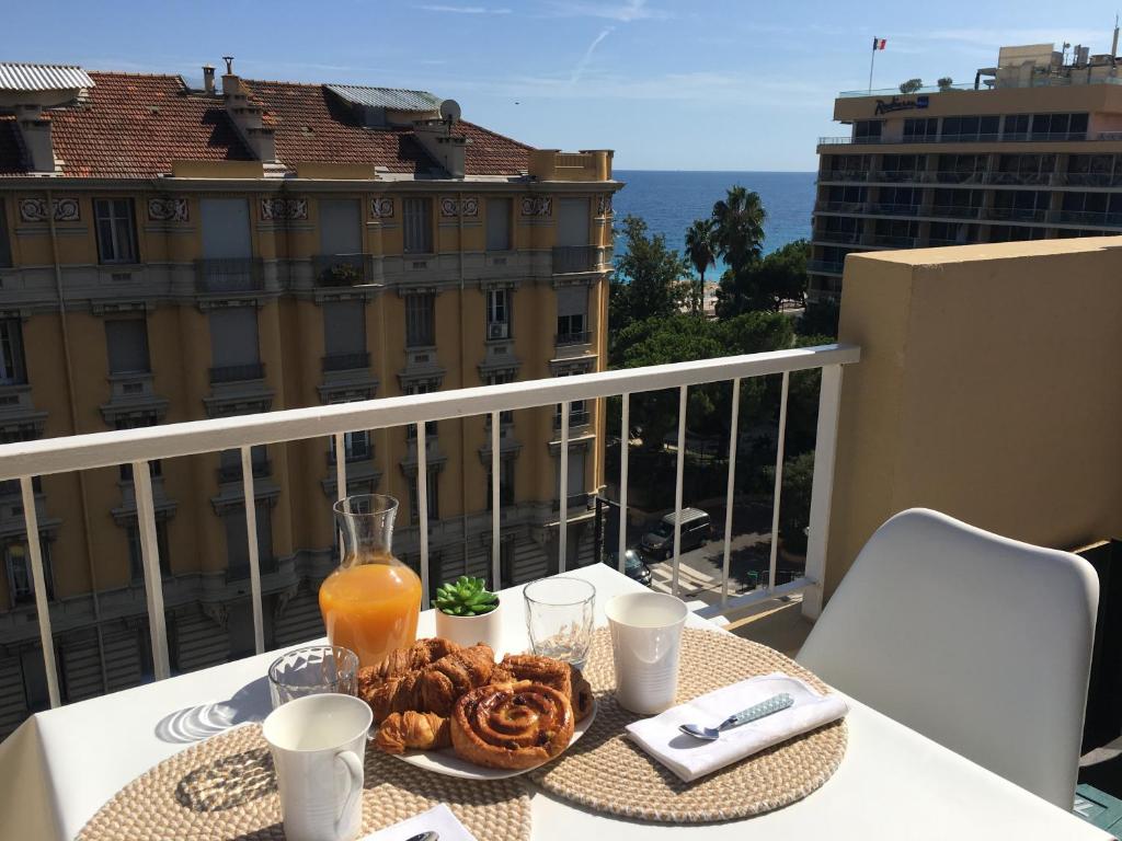 une table avec une assiette de nourriture sur un balcon dans l'établissement Studio 100m de la mer, à Nice