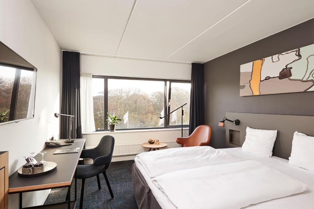 a hotel room with a bed and a desk at Comwell Kolding in Kolding