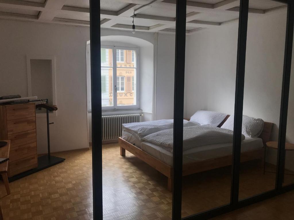 a bedroom with a bed and a dresser and a window at Albergo Diffuso Porrentruy in Porrentruy