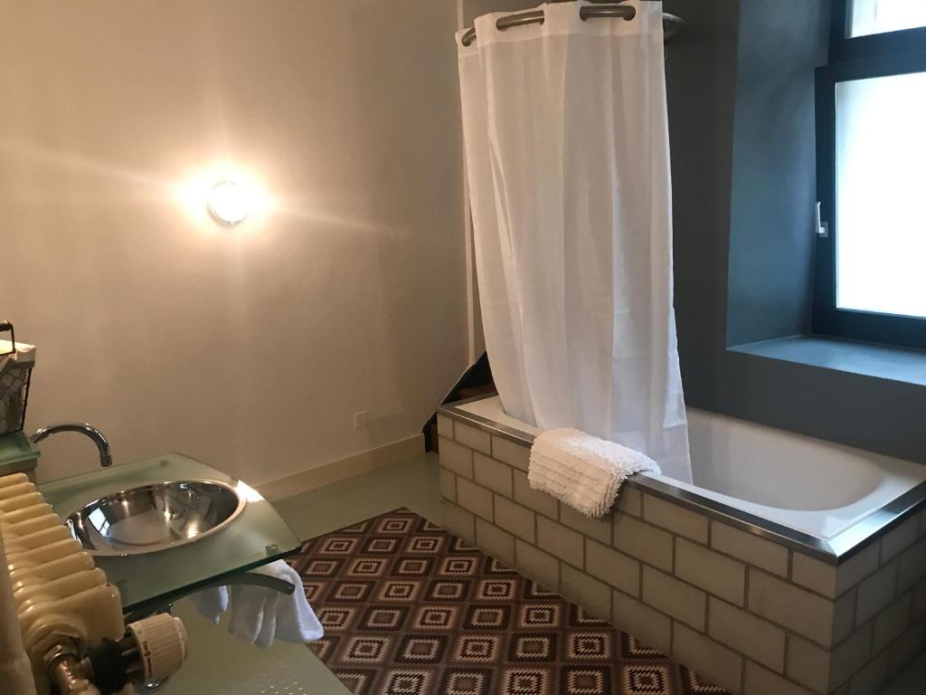 a bathroom with a tub and a sink and a shower at Albergo Diffuso Porrentruy in Porrentruy