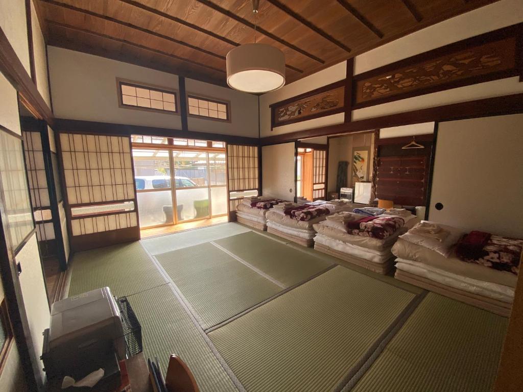Shichigahama的住宿－七濱町旅行者碼頭旅館，带窗户的客房内设有几张床。