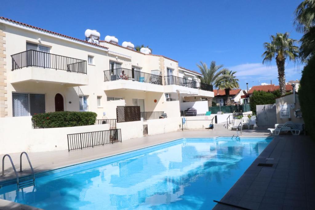 una piscina di fronte a un edificio di Cyking 2 bed Apartment with pool & 10 min to beach a Paphos