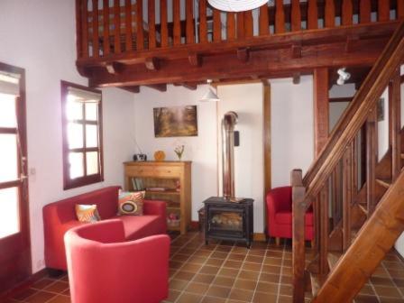 a living room with red chairs and a staircase at Magnimon 2 - Appartement rustique dans belle maison de village - Domaine Alpe d'Huez in Villard-Reculas