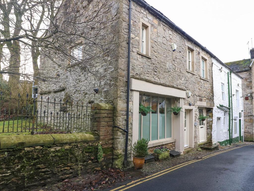 an old stone house on the side of a street at Blacksmith Cottage in Grassington