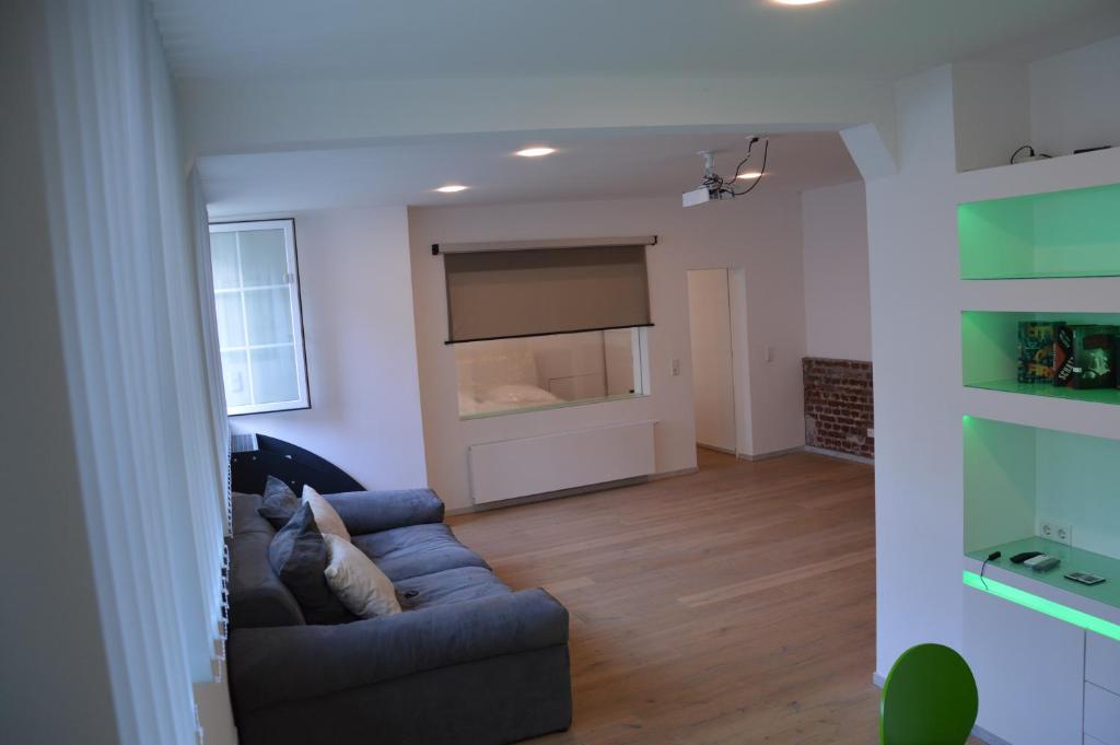 ヴッパータールにあるModern und Ruhig in Wuppertal mit Heimkino-Beamer! Top Ausstattung und Privatparkplatz an der Unterkunftのソファと窓のあるリビングルーム