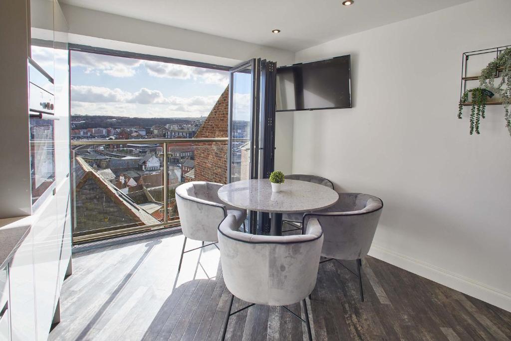 mesa y sillas en una habitación con ventana grande en Host & Stay - The View, Hudsons Yard House, en Whitby