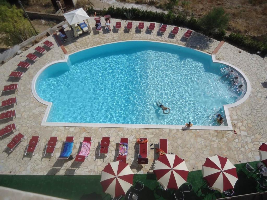 an overhead view of a swimming pool with chairs and umbrellas at Grand Hotel Sofia in Noto