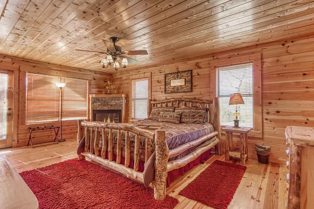 1 dormitorio con 1 cama en una cabaña de madera en Always and Forever-Get 951 worth of FREE area attraction tickets for each paid day!!!, en Pigeon Forge