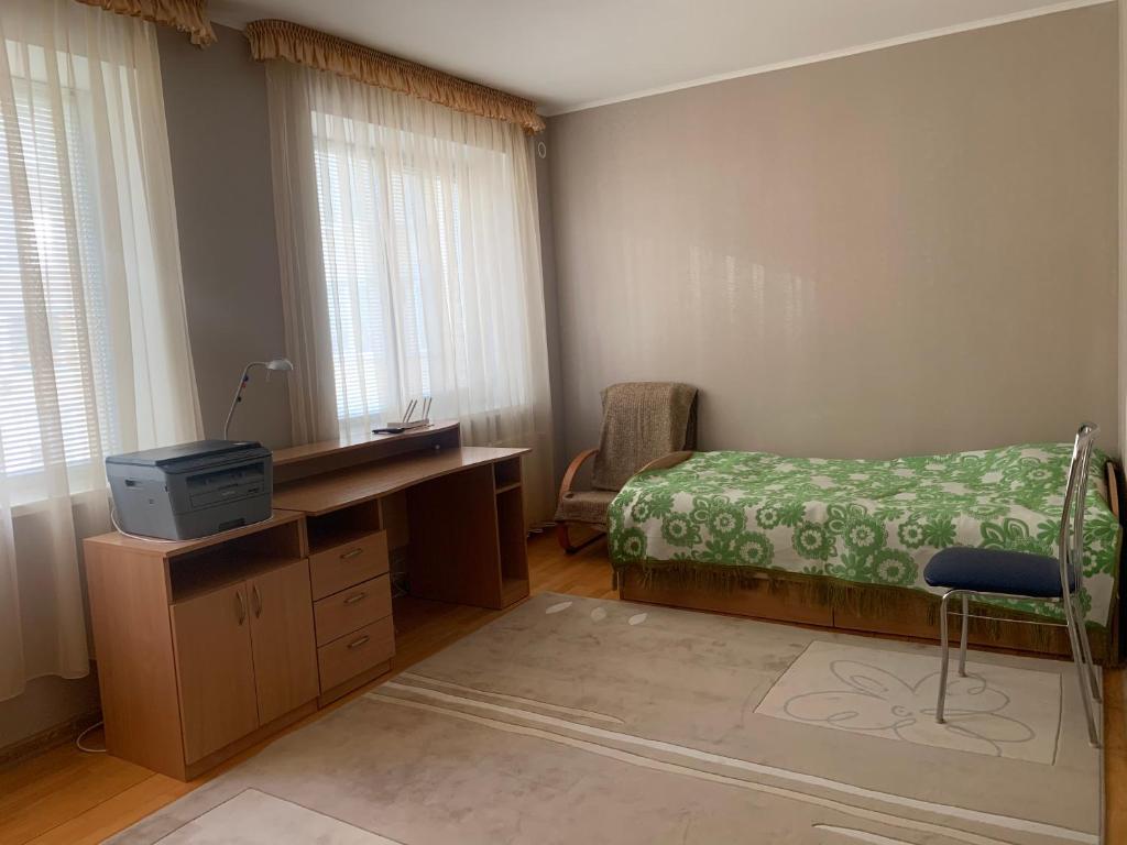 sypialnia z biurkiem, łóżkiem i oknem w obiekcie Bright room near International Exhibition Centre w Kijowie