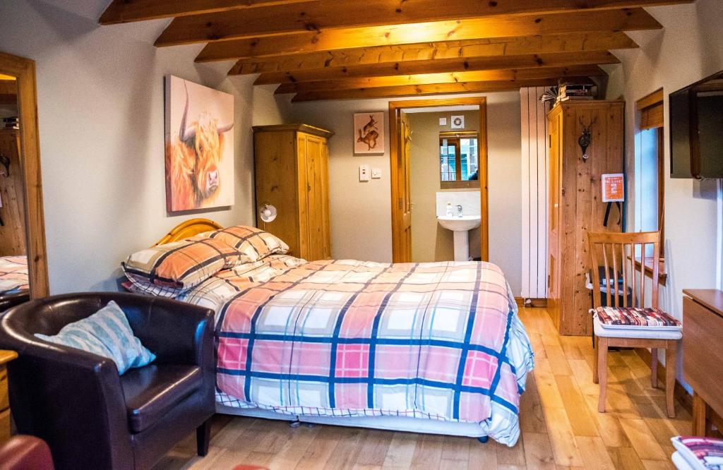 een slaapkamer met een bed, een stoel en een wastafel bij Kirkstyle Hideaway in Arbroath