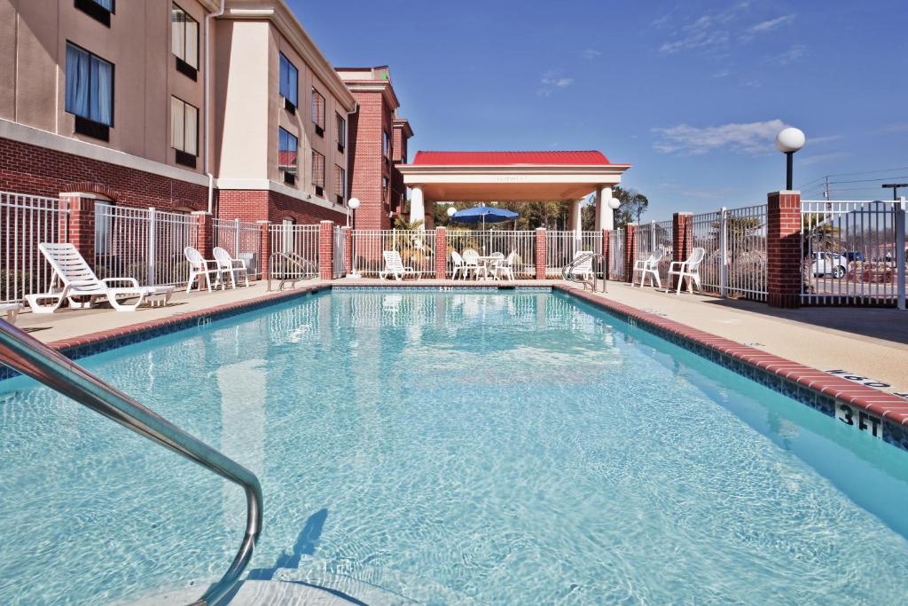una piscina con sillas y un edificio en Holiday Inn Express Hotel & Suites Forest, an IHG Hotel, en Forest
