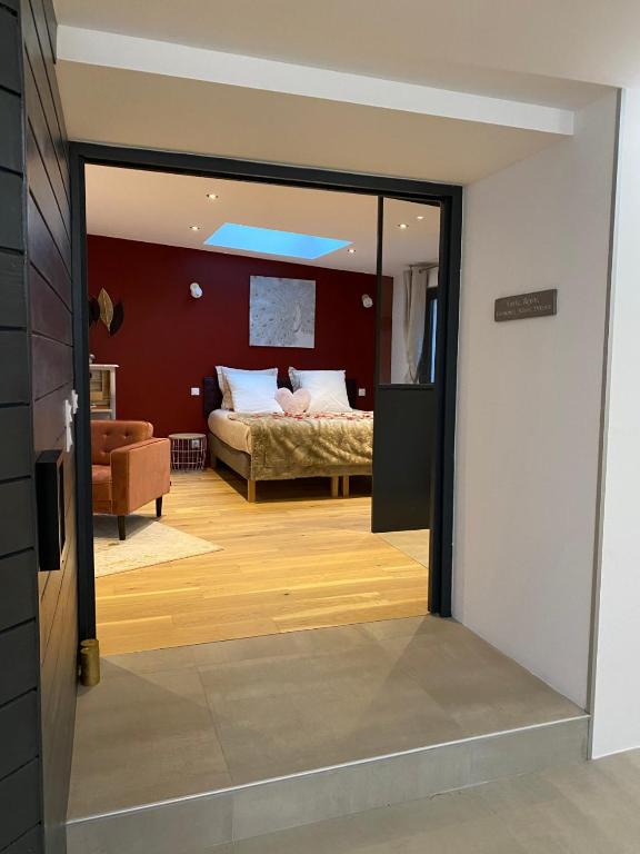 a view of a bedroom with a bed through a glass door at Les Suites de Bougainville in Concarneau