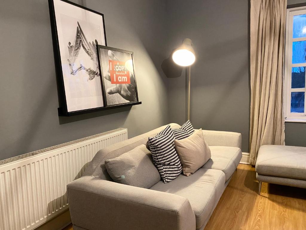a living room with a couch and a lamp at Alpheus Living: Newsham Apartment in Liverpool