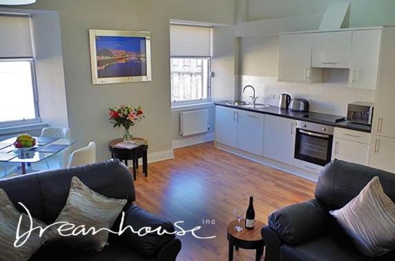 a living room with a couch and a kitchen at Dreamhouse Apartments Glasgow St Vincent Street in Glasgow