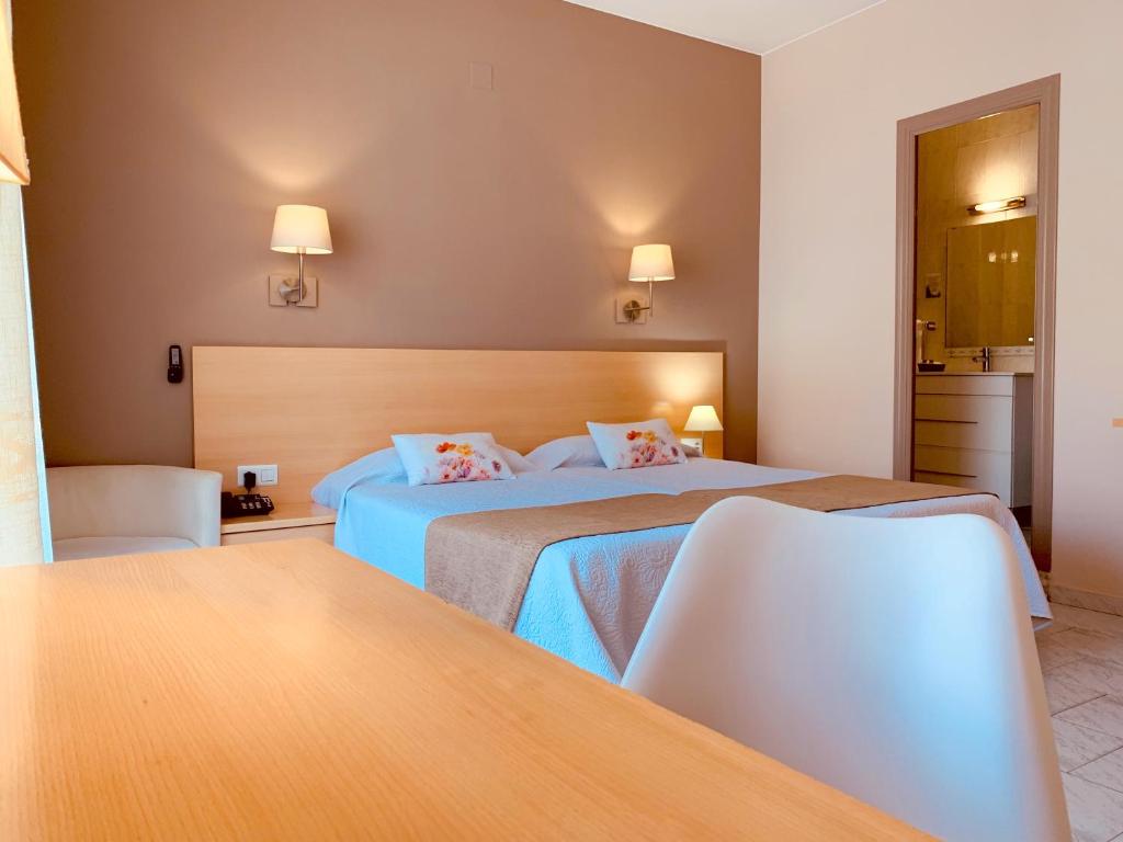 
a hotel room with two beds and a television at Hotel Restaurant Llansola in Sant Carles de la Ràpita
