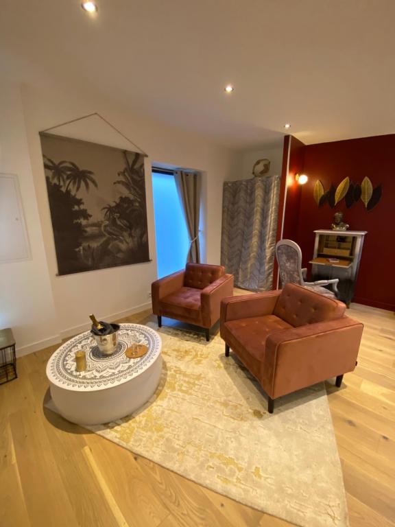 a living room with two couches and a table at Les Suites de Bougainville in Concarneau