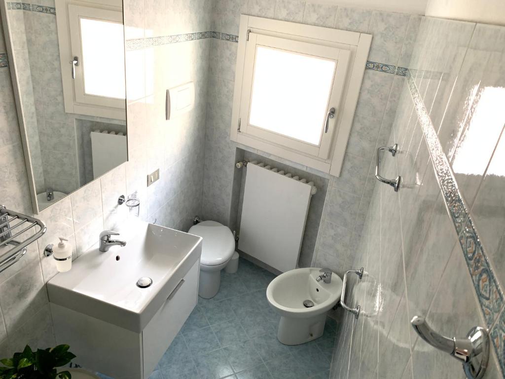 biała łazienka z umywalką i toaletą w obiekcie ROOFTOP TERRACE Domus dei fabbri w Wenecji