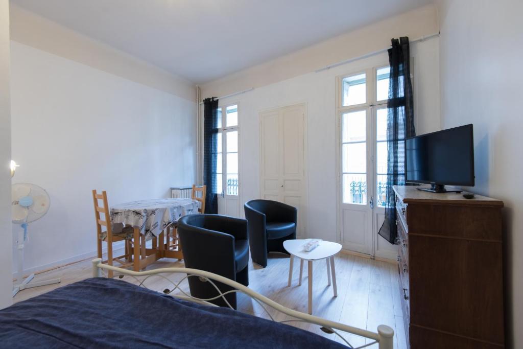 a living room with a bed and a table with chairs at T1 Rue CASTELLANE in Amélie-les-Bains-Palalda