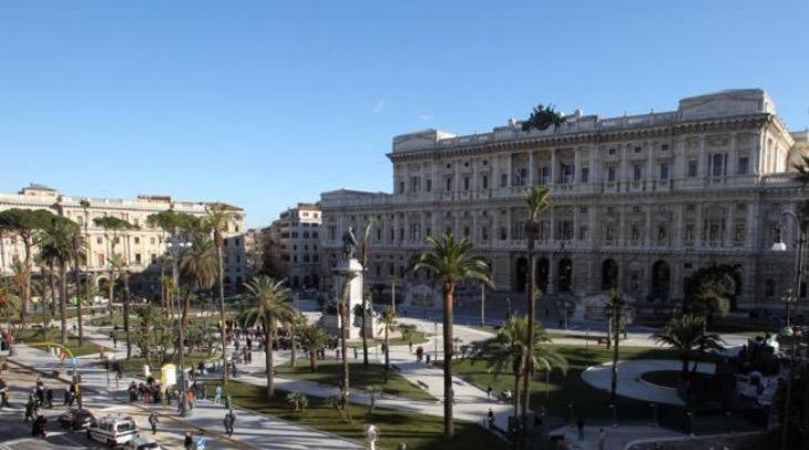 un grand bâtiment avec des palmiers devant lui dans l'établissement La stanza di Camillo, à Rome