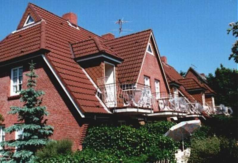 a red brick house with a balcony on it at Luettmarsch 13_ Whg_ 5 in Wyk auf Föhr