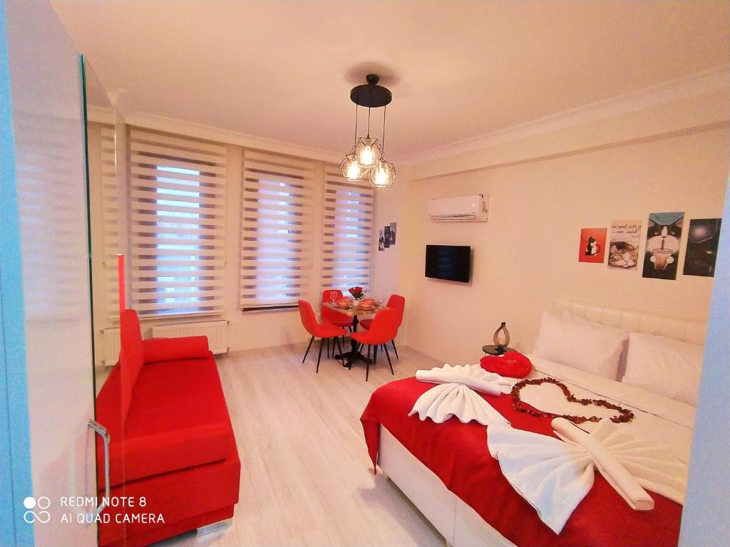 Un dormitorio con una cama roja y blanca y una mesa en Pera Colour House, en Estambul