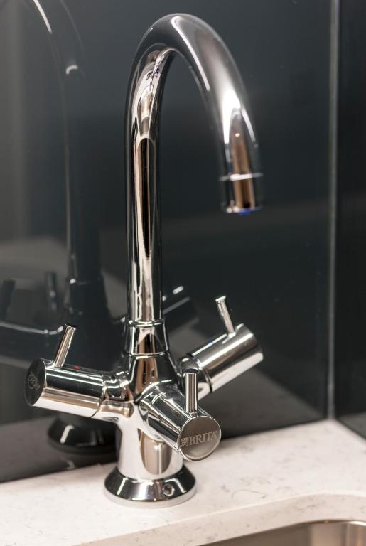 a bathroom sink with a chrome faucet at The Resident Victoria in London