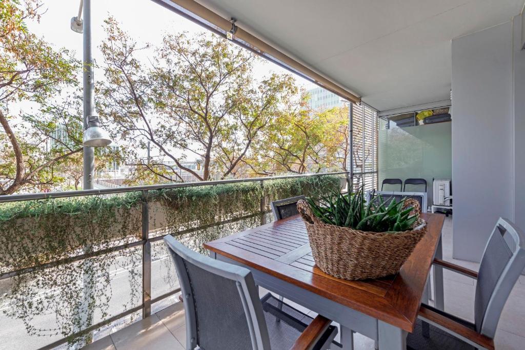 サン・アドリア・デ・ベソスにあるCCIB Forum Deluxe Apartmentのバルコニー(テーブル、椅子付)、大きな窓が備わります。