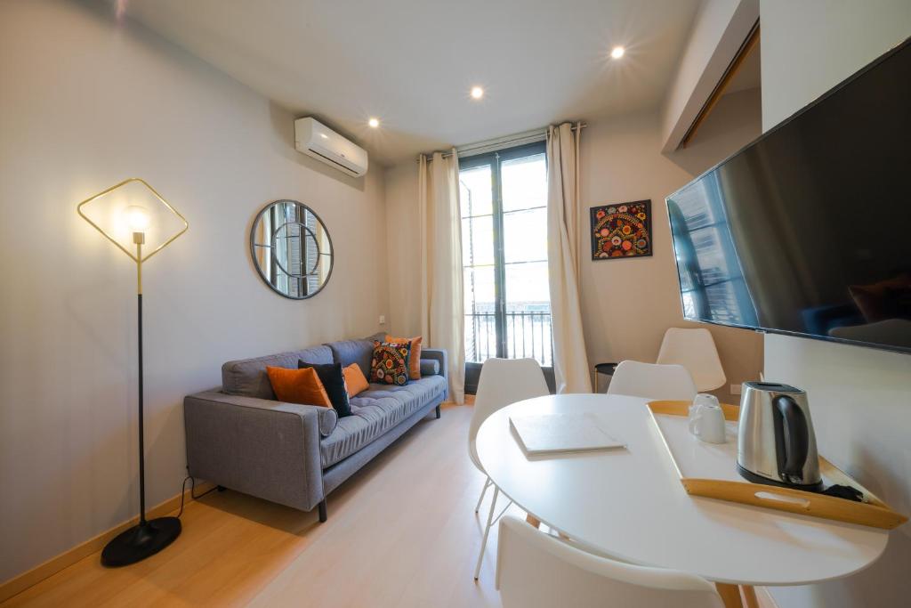 een woonkamer met een bank en een tafel bij Bonavista Apartments - Eixample in Barcelona