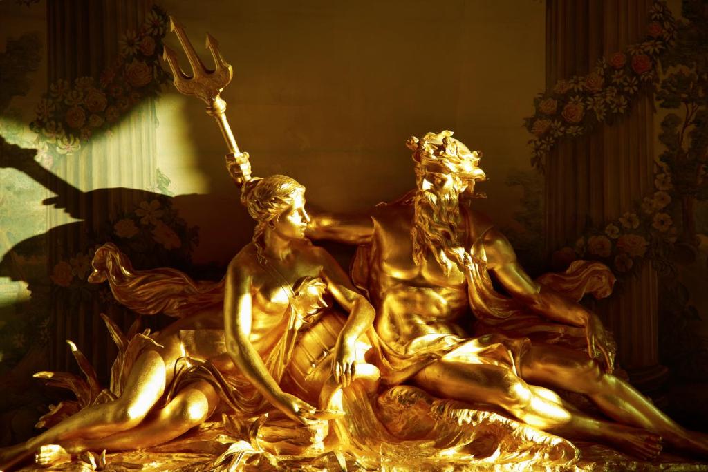 a gold statue of two people holding a fork at The Ritz London in London