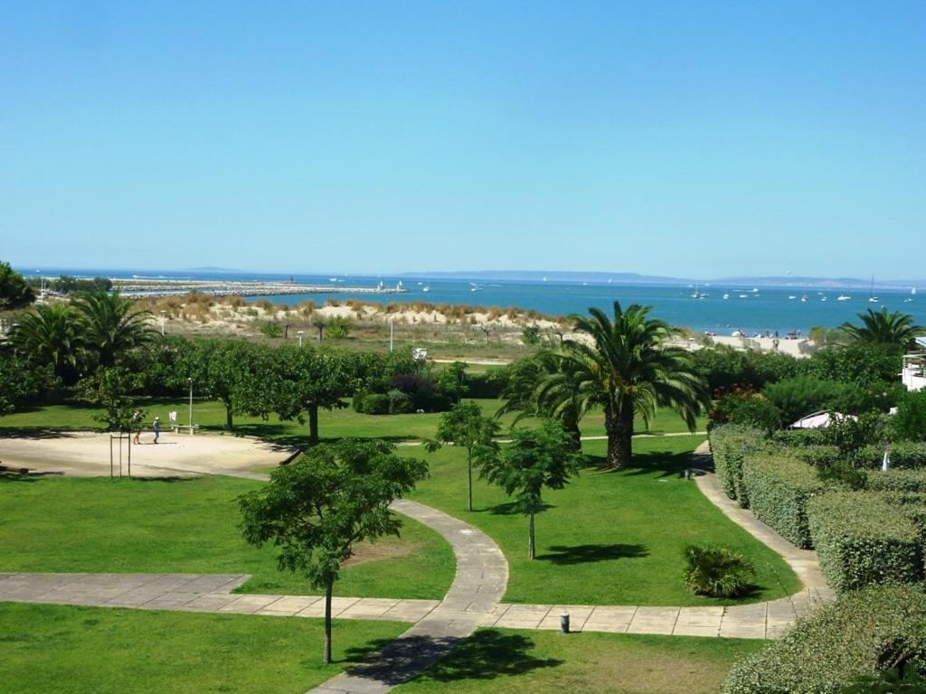 a park with palm trees and a path at AS13247 - P2 Cabine climatisé avec belle vue sur la Mer in Le Grau-du-Roi