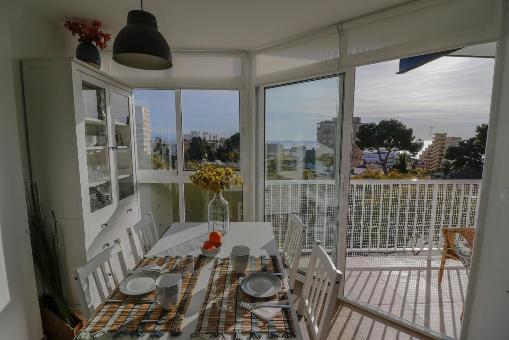een eetkamer met een tafel en stoelen op een balkon bij New, Sunny, Near The Beach With Sea Views in Benalmádena