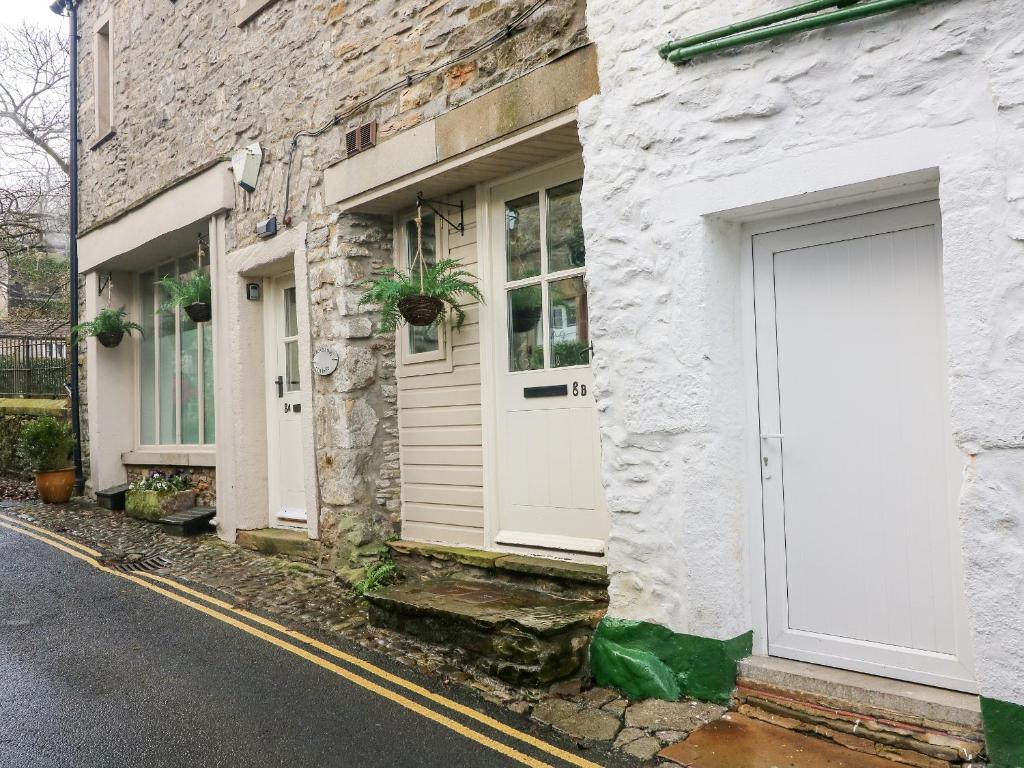 a white building with a door on a street at Lottie's Loft in Grassington